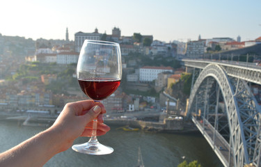 Wine glasses in the hands against Douro river in Porto, Portugal