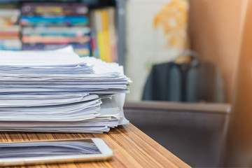 Pile of unfinished homework assignment documents of student on the teacher's desk. Stack of papers were not complete on table.