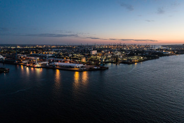 Obraz premium Aerial view of big cargo ship loading with containers at port of Hamburg, Germany. Beautiful sunset.