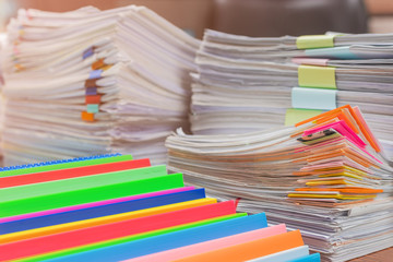 Close up pile of unfinished paperwork on office desk waiting to be managed. Stack of business paper. Report papers stacks. Business and finance concept.
