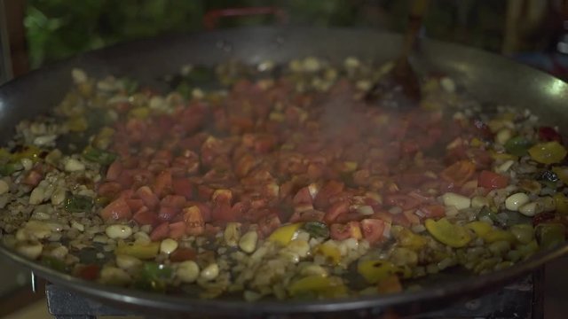 Fresh vegetables frying in olive oil on hot pan close up.Tomatoes, garlic, , onion and bulgarian pepper cooking at pan. Process stewing vegetable in restaurant kitchen.