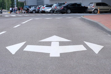 Road marking on asphalt. White arrow marking pointing ahead, left, right on road.