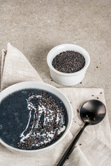 Trendy vegan food recipes, Black Sesame Soup with sesame seeds and coconut milk, grey stone table, copy space