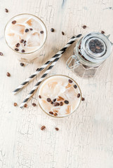 Fototapeta na wymiar Summer cold Iced coffee frappe with milk and ice cubes, light concrete background copy space top view