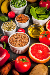 Healthy food background, trendy Alkaline diet products - fruits, vegetables, cereals, nuts. oils, dark blue concrete background
