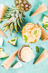 Summer holiday vacation concept, set various tropical ice cream sorbets, frozen juices in pineapple, grapefruit and coconut, light blue concrete background copy space
