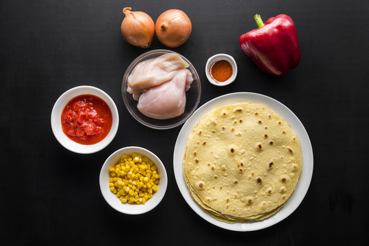 Ingredients for the preparation of quesadilla with chicken: tortilla, corn, chicken, onion, tomatoes and pepper, top view