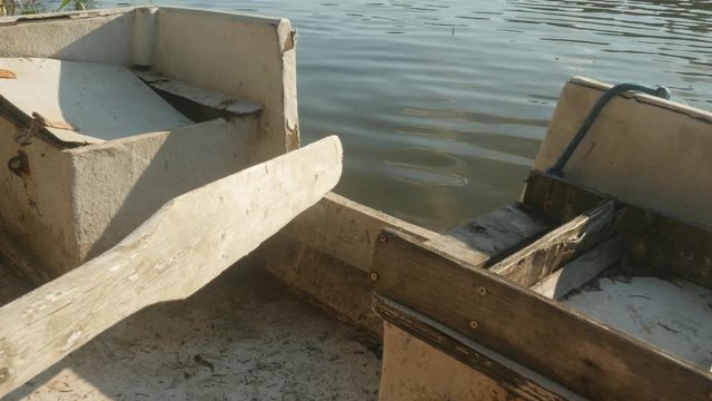 wooden oar in an old boat moored to the shore of the lake