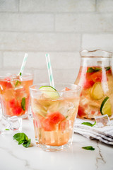 Iced watermelon and lime green tea with mint leaves, marble white background copy space