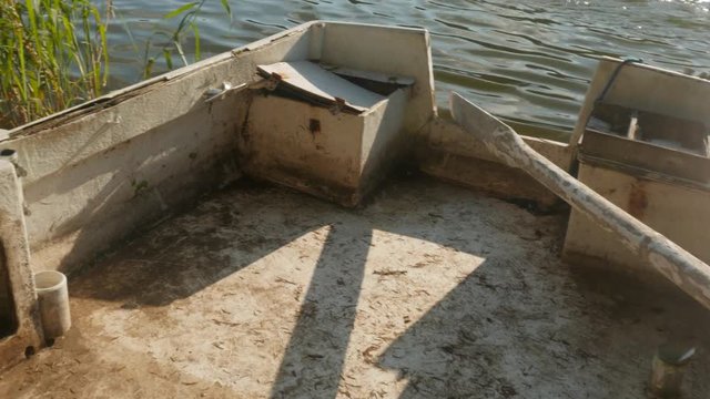 wooden oar in an old boat moored to the shore of the lake