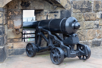 Fototapeta na wymiar Medieval cannon at loop-hole in Edinburgh Castle, Scotland
