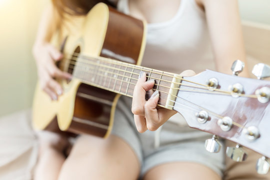 woman playing guitar in bedroom for singing music and relax feeling so happiness and enjoy with it