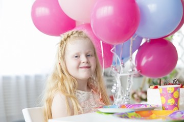 Fototapeta na wymiar birthday of a little girl - a festive table and bright colorful balloons