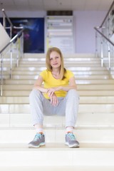 modern woman in casual clothes sits on store steps