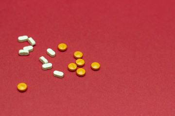Medicine concept, pills on a red background.