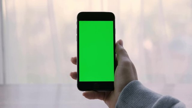 Close-up of a woman&rsquo;s hands holding a smartphone.