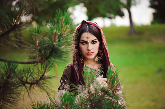 Beautiful Arabian woman portrait. Young Hindu woman with mehndi tattoos from black henna on her hands.