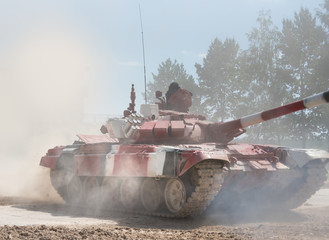 Military or army tank ready to attack and moving over a deserted battle field terrain. a lot of dust. copyspace