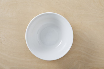 White empty plate on wooden table. Top view.