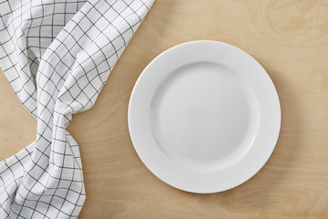 textile cell napkin on wooden table with copy space and white empty plate