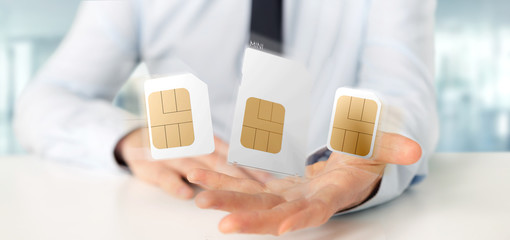 Businessman holding Different size of a smartphone sim card 3d rendering - obrazy, fototapety, plakaty