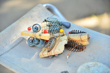 Fishing equipment and gears lie on a folding chair, hooks, floats, loads, fishing line, spring.