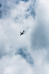 low angle view of airplane flying in blue cloudy sky