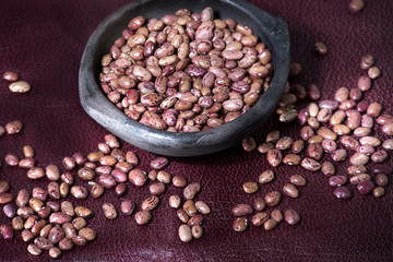 pink uribe bean in clay bowl on red background