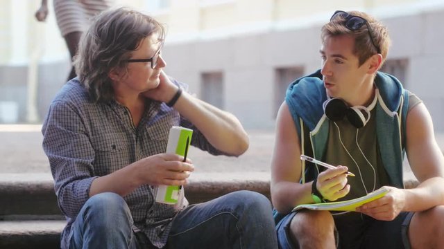 European Student And Professor Sitting On Stairs Outdoors