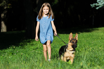 Naklejka na ściany i meble little girl and a puppy on a walk
