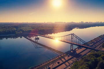 Skyline, Kiev city with beautiful morning sky. Pedestrian bridge. Left bank the Dnieper River. Aerial view. Sunrise over city