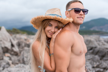 portrait of girlfriend touching shirtless boyfriend at beach in Montenegro