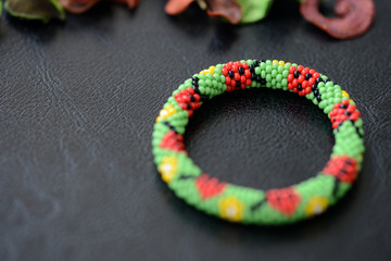 Children's bracelet with the image of ladybugs on a dark background close up