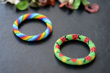 Two kid's bracelets from beads on a dark background close up