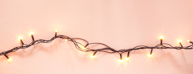 Yellow garland on a pink background. Holiday Christmas concept