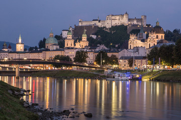 Fototapeta na wymiar Die Festung Hohensalzburg mit der Salzach und dem Makartsteg im Vordergrund am Abend 