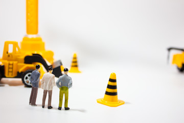 Miniature businessman in miniature construction site.