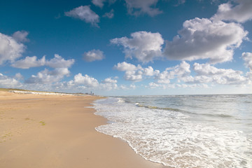 Obraz premium Bank of the blue sea with wet sand and clouds