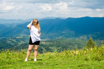 Obraz premium A young girl loves to travel and conquer the peaks of the mountains