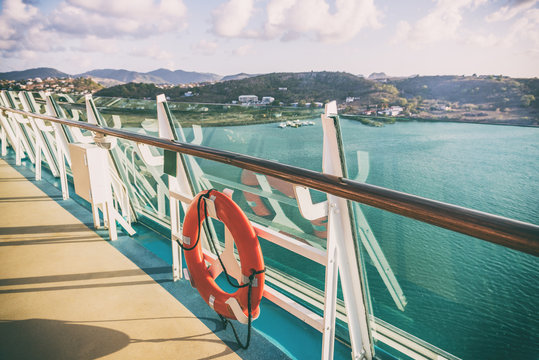 Cruise ship Caribbean vacation travel tropical holidays. View of landscape at sunset from boat balcony deck with railing and red lifebuoy. Getaway on sea.
