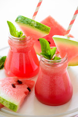 Summer watermelon smoothie decorated mint leaves on pink background. Summer drink concept