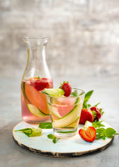 Strawberry and cucumber soda on grey background