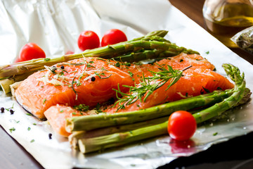 Salmon fillet seasoned with various spices on black background