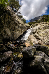 Waterfall flowing between the rocks to the beach.
