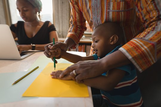 Father assisting her son to draw a sketch