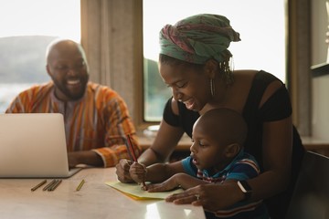 Mother assisting her son to draw a sketch