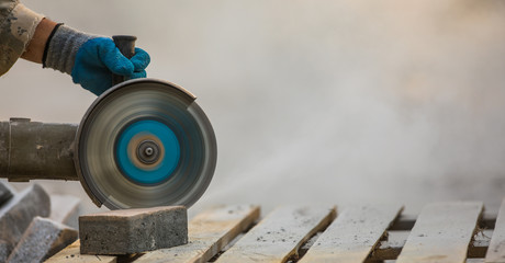 worker cuts stone tiles with electric saws