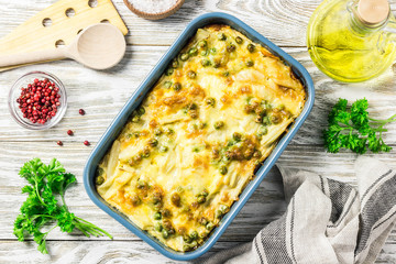 Healthy yellow string bean casserole with green peas and parmesan cheese. Top view, space for text. - obrazy, fototapety, plakaty