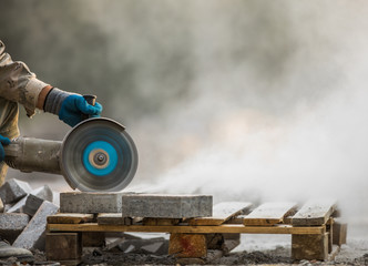 grinder worker cuts a stone the electric tool,street construction work