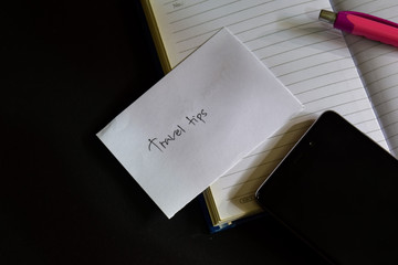travel tips word written on paper. travel tips text on workbook, Black background concept